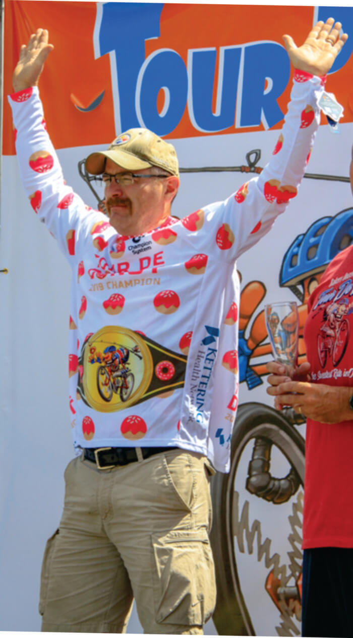 Man raising his arms in victory on award stage