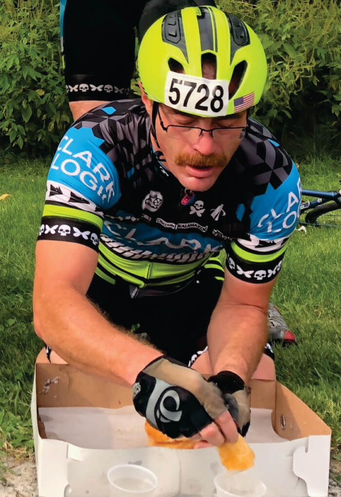 Man in cycling gear eating a donut